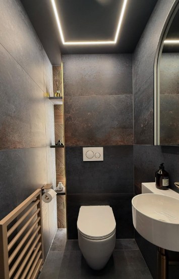 Charcoal cloakroom with LED ceiling strip, floating basin and backlit niche shelving