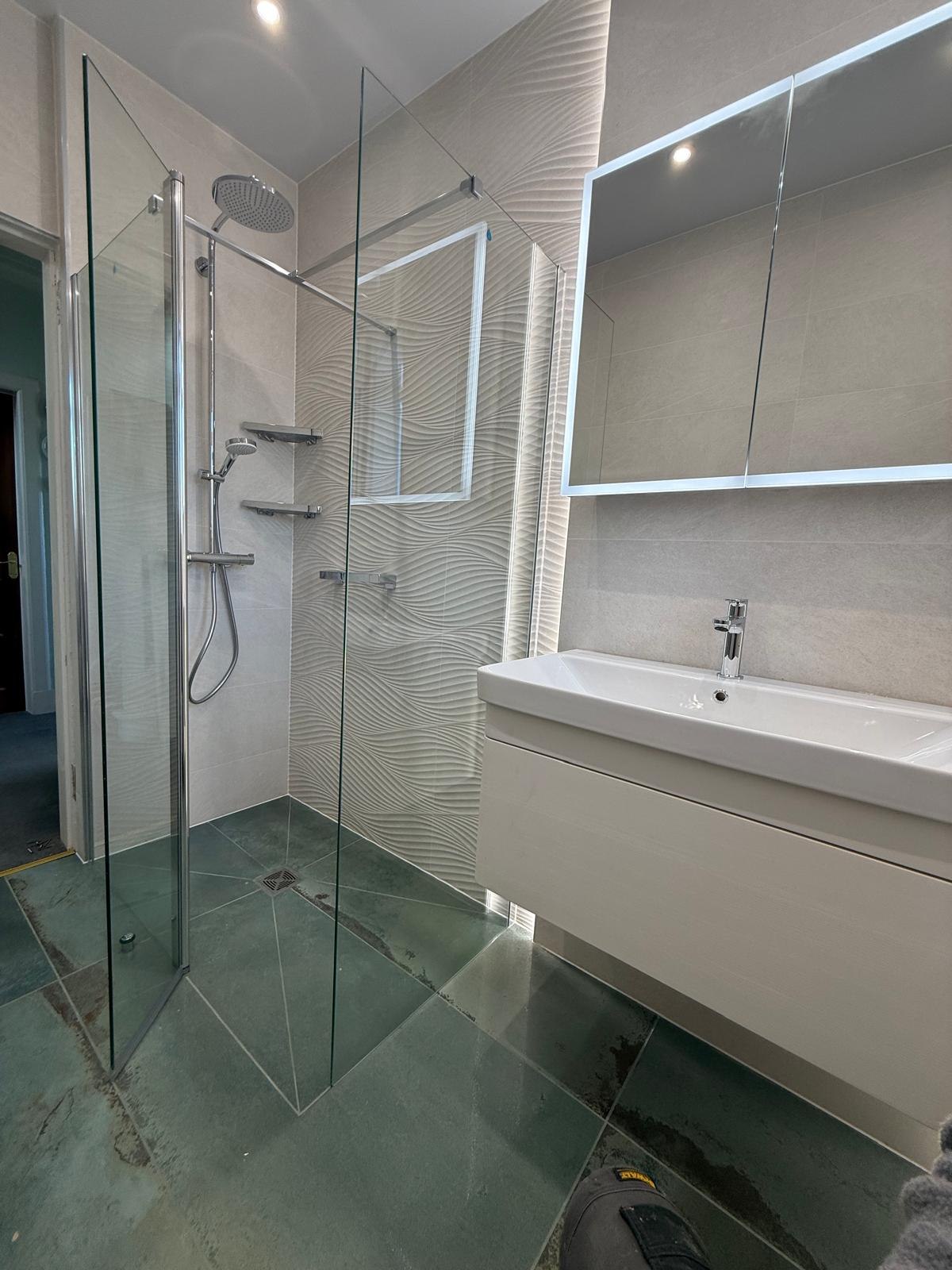 Main bathroom with 3D textured tiles, green stone floor and frameless wet-room shower