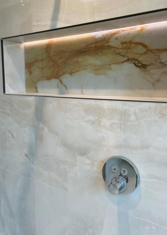 Onyx-effect porcelain shower wall with wide illuminated storage niche